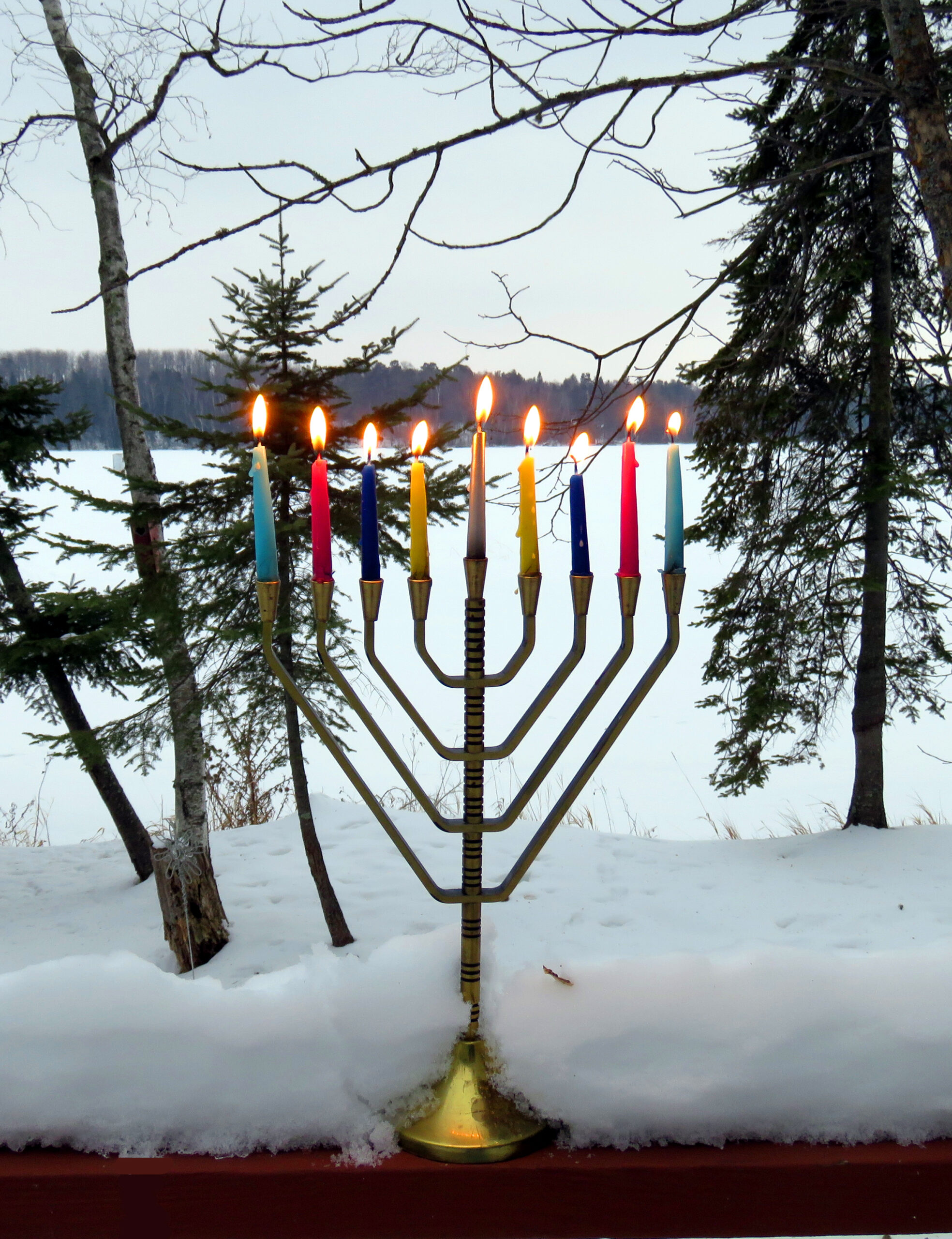 Winter -- Lighted Chanukah Menorah in Snow Against Frozen Lake